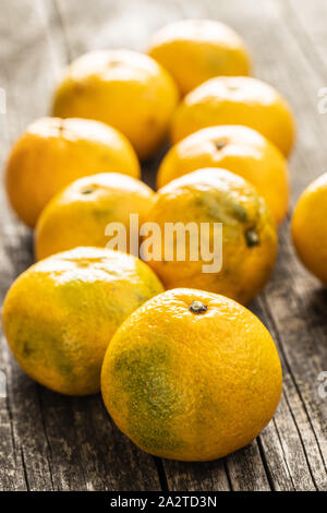 Frische gelb Mandarinen auf alten Holztisch. Stockfoto