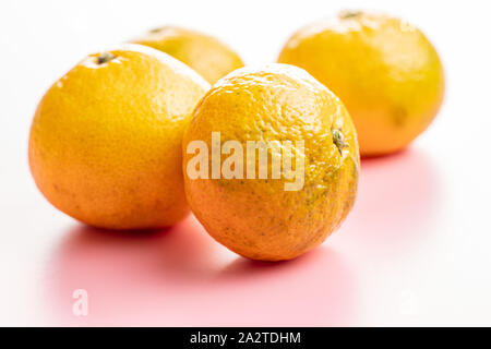 Frische gelb Mandarinen auf rosa Hintergrund. Stockfoto