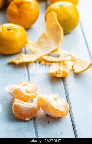 Frische Mandarinen gelb auf blau Holztisch. Stockfoto