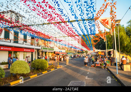 Loreto, Madeira, Portugal - Sep 7, 2019: Schöne bunte Straße Dekoration während der Feier der Religiösen fest. Papier Blumen in der Luft hängen. Die Leute feiern, Stände mit Essen. Stockfoto