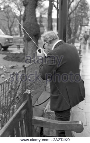 Ein Mann in Edinburgh Princes Street mit einem frühen Handy in 1985 Stockfoto