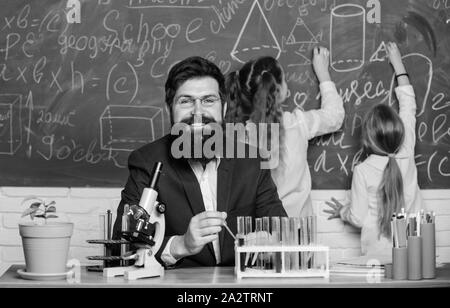 Faszinierende Biologie Lektion. Schule Lehrer der Biologie. Man bärtige Lehrer arbeiten mit Mikroskop und Reagenzgläser in Biologie Klassenzimmer. Erklärt Biologie für Kinder. Wie Interesse Kinder studieren. Stockfoto