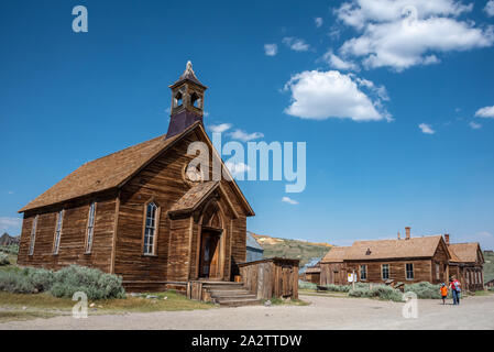 Alte methodistische Kirche Außenansicht bei Bodie mit Besuchern zu Fuß die Straße runter von der Geisterstadt in der östlichen Sierra von Kalifornien. Stockfoto