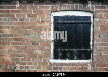 Schwarze Hölzerne verriegelt Heckklappe in alten ländlichen Brick Nebengebäude Stockfoto