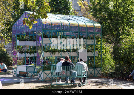 Drei Männer auf einer Bank von hinten mit Gewächshaus vor Smithfield Rotunde Garten West Smithfield, City of London, England Großbritannien UK Stockfoto