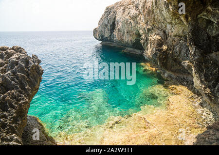 Versteckte Bucht mit Felsen und türkisem Wasser in den Ozean in Ayia Napa Cape Greco National Forest Park, Zypern Stockfoto