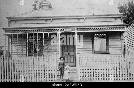 Negative - North Melbourne, Victoria, ca. 1890, ein kleiner Junge und ein kleines Mädchen stand im Tor von einem kleinen Haus. Der Name "Ethel" erscheint über der Veranda. Es gibt Einsätze auf der linken Seite der Veranda und einem Weinstock wird an Ihnen geschult Stockfoto