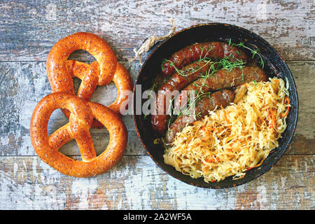 Oktoberfest essen. Bayerische Wurst und Sauerkraut in der Pfanne. Bayerisches Bier frisch essen. Oktoberfest. Selektive konzentrieren. Makro. Stockfoto