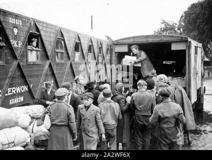 Digitale Fotografie - Vertriebenen Queuing für Verbrauchsmaterial, Region Salzgitter, Deutschland, 1946, schwarz-weiß Foto von einer Gruppe von vertriebenen Personen, die in der Warteschlange sind für Lieferungen von der Rückseite der Krankenwagen von Enid Whitton, einer der Englischen Lager Arbeiter entladen wird. Die Leute sind polnische Vertriebene aus Lagern in der Region Salzgitter Deutschland repatriiert, aus heerte Bahnhof in 1946. Der Schlitten hat "Krakau" auf der Seite gemalt. Er ist einer der Stockfoto