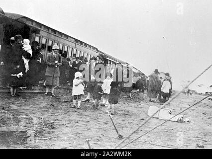 Negative - Gruppe der Inspektion "Bessere Landwirtschaft Train', Underbool, Victoria, 1927, eine Gruppe, überwiegend Frauen, neben Eisenbahnwaggons. Dies war die "Bessere Landwirtschaft Train". Die Frauen ein tragen Röcke und Jacken und Kleidung Schuhe. Einige der Frauen tragen Hüte. Eine Gruppe von Kindern vor der Frauen, die Mädchen tragen kurze kleider und lange Socken, und die Jungen in kurzen Hosen und Jacken. Auf der linken Seite, eine Frau hält ein Baby gewickelt ist, Stockfoto