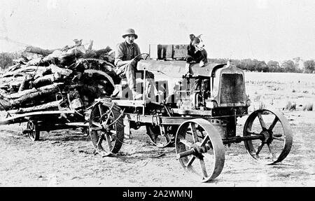 Negative - Charlie Gillett Fahren einen Selbstgenähten Traktor, Shelford, Victoria, ca. 1920, Charlie Gillett fahren ein Traktor. Er baute er zusammen mit seinem Bruder Alf. Der Traktor ist eine Last von Holz und es ist ein Hund auf der Motorhaube des Traktors sitzen Stockfoto