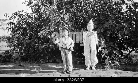 Negative - Manangatang, Victoria, ca. 1935, zwei Jungen in Fancy Dress. Man wird wie ein minnesänger gekleidet und hält eine Ukulele, die andere als Clown verkleidet ist Stockfoto