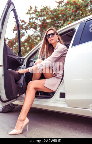 Schöne moderne Mädchen steigt aus dem Auto innen weiß Business Class,  modische stilvolle Business Woman, Sommer Frühling Herbst Frau. VIP-Taxi,  Rosa Stockfotografie - Alamy