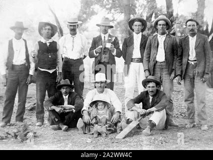Negative - Wentworth District, New South Wales, ca. 1905 Mitglieder einer Cricket Team. Der Mann vor hält ein kleines Mädchen Stockfoto