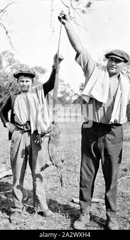 Negative - balranald District, New South Wales, ca. 1925, ein Mann und eine junge einen goanna Stockfoto