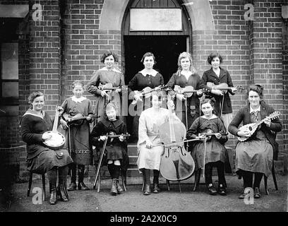 Negative - Casterton, Victoria, 1920, eine Gruppe von Schülerinnen, mit ihren Musikinstrumenten, auf den Stufen des Klosters der Barmherzigkeit. Sieben der Mädchen halten, Violinen, ein Banjo, eine Mandoline und ein Cello Stockfoto