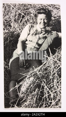 Fotografie - Esma Banner, circa 1950, Foto von Esma Banner mit einer Kamera und Sitzen in, was scheint, ein Bündel Heu zu werden. Esma Banner arbeitete in Camps Vertriebene" in der US-Zone Deutschlands nach dem Zweiten Weltkrieg als Beschäftigung und Wohlfahrt Offizier für das Hilfswerk der Vereinten Nationen und Rehabilitation Administration" (Unrra) und der Internationalen Flüchtlingsorganisation (IRO), von 1945 bis 1951. Esma war einer von 39 Australiern, die Stockfoto