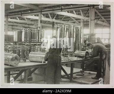 Fotografie - Hecla Elektrik Pty Ltd, Arbeiter, Zusammenbauen Wasser Zylinder, ca. 1920, schwarz-weiß Foto von Hecla Mitarbeiter Montage wasser Zylinder, möglicherweise an der Little Collins Street in Melbourne getroffen, ca. 1920er-Jahre. Die Kleidung der Arbeiter zeigt an, dass das Bild in den 1920er Jahren, einer Zeit, in der der Fokus des Geschäfts war die Verlagerung von Heizkörpern, Beleuchtung und Kunst Metall zu Haushaltsgeräten. Die Ausstattung ist einfach und Endbearbeitung Stockfoto