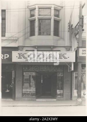 Fotografie, Kodak House Shop Exterieur, Hobart, Tasmanien, 22 Okt 1935, Schwarz-weiß Fotografie shop Front die Kodak Australasia Pty Ltd "Kodak House' auf Elizabeth St, Hobart, Tasmanien am 22. Oktober, 1935. Diese street view zeigt das Fenster zeigt in der vorderen Eingang, der Kodak Markise unterzeichnen und ein Mann ist in der ersten Geschichte Fenster sichtbar. Diese Kodak Shop wurde im Jahre 1920 gebaut, mit der zweiten Geschichte im Jahre 1929 aufgenommen. Oben war die Verarbeitung Lab für den Druck Stockfoto