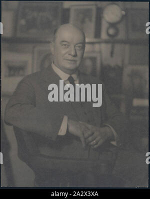 Fotografie, Portrait von John Joseph Rouse, ca. 1925-1935, Schwarze und Weiße fotografische Porträt mit Kodak Australasia Pty Ltd Geschäftsführer John Joseph (J.) Rouse ca. 1925-1935. Es erscheint in seiner Studie genommen worden zu sein, mit der Familie Portraits hinter ihm angezeigt. hergestellt und ein breites Spektrum an fotografischen Produkte, Australasien, wie Film, Papier, Chemikalien, Kameras und sonstige Ausrüstungen verteilt. Ihre Kundenbasis Stockfoto
