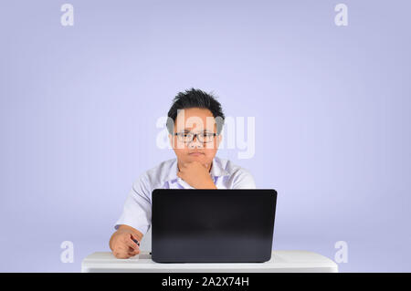 Eine ernsthafte Suche Schüler denken. Junge männliche Kursteilnehmer in die Kamera schaut. Studio shot in Weiß isoliert Hintergrund. Sehr konzentrierte Geschäftsmann. Stockfoto