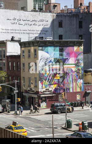 10. Ave. und 18 St. Blick auf die Chelsea Square Markt und Mutter Teresa und Mahatma Gandhi Wandmalerei von Kobra aus der High Line. Die High Line ist voll mit Touristen von morgens bis abends mit seiner einzigartigen Flora, Kunst und Blick auf Manhattan von diesem erhöhten Park auf der Westside von Manhattan. Stockfoto