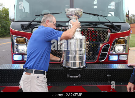 St. Louis, USA. 03 Okt, 2019. Ehemalige St. Louis Blues defenseman und Mitglied der National Hockey League Hall of Fame Al MacInnis, Orte der Stanley Cup auf der Vorderseite eines St. Louis Feuerwehr Lkw für ein Foto, am Donnerstag, 3. Oktober 2019. Der Stanley Cup, von den St. Louis Blues im Juni 2019 gewann, ist eine abschließende Tour rund um die St. Louis Bereich vor der Rückkehr in die Hockey Hall of Fame. Foto von Bill Greenblatt/UPI Quelle: UPI/Alamy leben Nachrichten Stockfoto