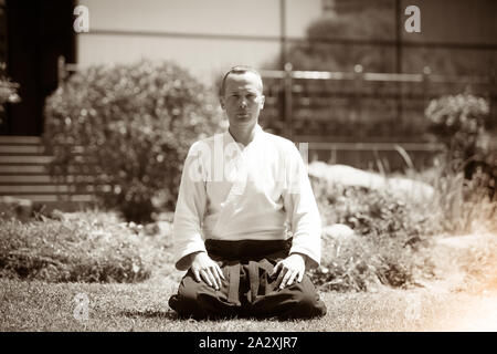 Junge ernster Mann aikido Master in traditioneller Tracht Stockfoto