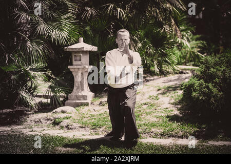 Junge ernster Mann aikido Master in traditioneller Tracht Stockfoto