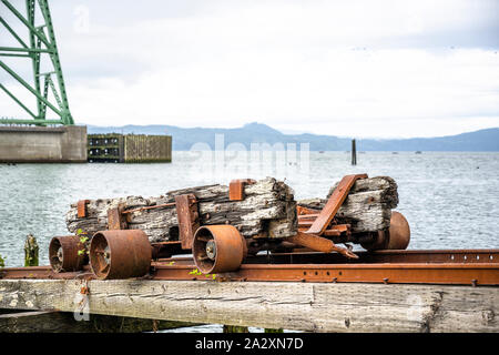 Eine alte rostige Trolley für das Be- und Entladen von Luftfracht steht auf den Schienen auf Stelzen ins Wasser des Pazifischen Ozeans in Astoria in der Nähe der Bri Stockfoto