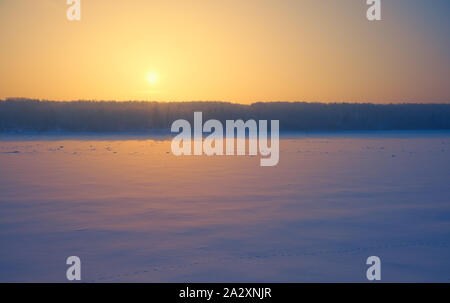 Sonne über sibirische Wald und Fluss Tom unter dem Schnee und Eis am Abend Sonnenuntergang im Winter Saison. Stockfoto