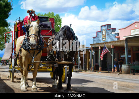 Zwei Pferde Rest beim erwarten Passagiere mit Cowboy auf Stagecoach auf einem alten West Street im historischen Tombstone, AZ Stockfoto