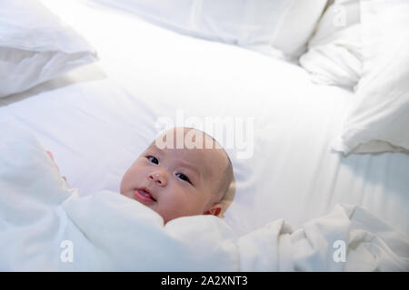 Cute 4 Monat asiatische Kind liegt in einem weißen runden Bett Stockfoto