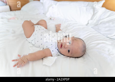 Cute 4 Monat asiatische Kind liegt in einem weißen runden Bett Stockfoto