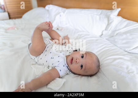 Cute 4 Monat asiatische Kind liegt in einem weißen runden Bett Stockfoto