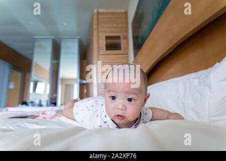 Cute 4 Monat asiatische Kind liegt in einem weißen runden Bett Stockfoto