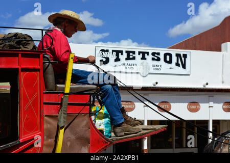 Cowboy treibt eine rote Postkutsche Inbusschlüssels Straße neben Stetson Hut shop in historischen Tombstone, AZ, USA Stockfoto