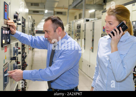 Ingenieur und Geschäftsfrau, die auf dem Handy in Data Center Stockfoto