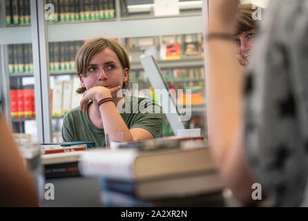 20. August 2019, Hessen, Frankfurt/Main: Der 13-jährige Hendrik hört zu, wie die anderen Mitglieder der "JungeMedienJury" (Jmj) an einer der Sitzungen in der Frankfurter Zentrale Bibliothek. Auf der rechten Seite ist Roswitha Kopp, Mitglied der Bibliothek Personal. Im Ausschuss, 13- bis 16-Jährige aktuelle Buchtitel diskutieren und am Ende ein Sieger gewählt und weitere Empfehlungen gemacht werden. Foto: Frank Rumpenhorst/dpa Stockfoto