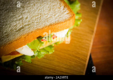 Helle saftige Sandwich mit Kräutern und Tomaten auf einem Schneidebrett Stockfoto