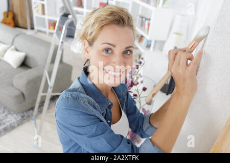 Portrait von Frau Malerei Wand mit Pinsel Stockfoto
