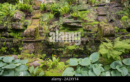 Hever Castle Garten, Pergola entfernt. Wunderschöne Wand mit geformten Stein, Grün und einem kleinen Bachlauf. Horizontales Format. Kent, England. Stockfoto