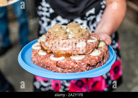 Hochzeitstorte raw Atriaux Boden Schweinefleisch Küche Burger auf einen Schiefer Fach mit Zwiebel, Rosmarin, Pfeffer und Salz, serviert auf einer Hochzeit close-up Stockfoto