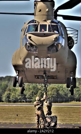 Schüler der 89 B Munition liefern Kurs verbinden ein mock Munition Palette zu einem CH-47 Chinook Hubschrauber Aug 1, 2019, als Teil der Schlinge - last Ausbildung bei Sparta-Fort McCoy Flughafen am Fort McCoy, Wis die Chinook und die Crew sind ab dem 7. Bataillon, 158 Aviation Regiment des neuen Jahrhunderts, Kansas. Die Munition liefern, von der 13 Bataillon gelehrt, 100 Regiment am Fort McCoy, ist einen 4-wöchigen Kurs, der eine Schulung für die Soldaten, die Umgliederung der 89 B militärische berufliche Spezialität sind. Die Schlinge - last Training ist einer der letzten großen Ausbildung Veranstaltungen während des Kurses. Ein s Stockfoto