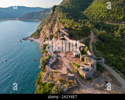 Luftaufnahme von Mogren Festung, Tvrdava Mogren, es liegt auf einem Vorgebirge Mogren entfernt. Budva. Montenegro. Zerklüftete Küste Stockfoto