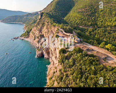 Luftaufnahme von Mogren Festung, Tvrdava Mogren, es liegt auf einem Vorgebirge Mogren entfernt. Budva. Montenegro. Zerklüftete Küste Stockfoto