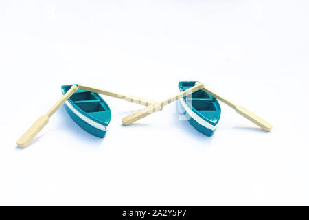 Paar blaue Miniatur Boote mit Rudern mit Schatten auf weißem Hintergrund isoliert. Zwei blaue Spielzeug Schiffe Stockfoto