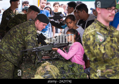 ABBOTSFORD, BC, KANADA - 11. AUG 2019: Ein Soldat der kanadischen Streitkräfte zeigt Kindern auf der Abbotsford International Airshow ein automatisches Gewehr. Stockfoto