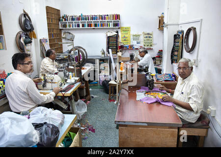 Schneider in ihren Shop sitzen an einer Nähmaschine, schöne Designs in Maskat, Oman. Stockfoto