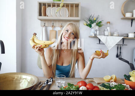 Schöne Mädchen machen einen Salat. Sportliche Blondine in einer Küche Stockfoto